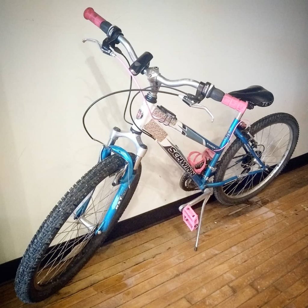 blue and white small frame mountain bike with hot pink handlebars, hot pink bottle cage, hot pink pedals